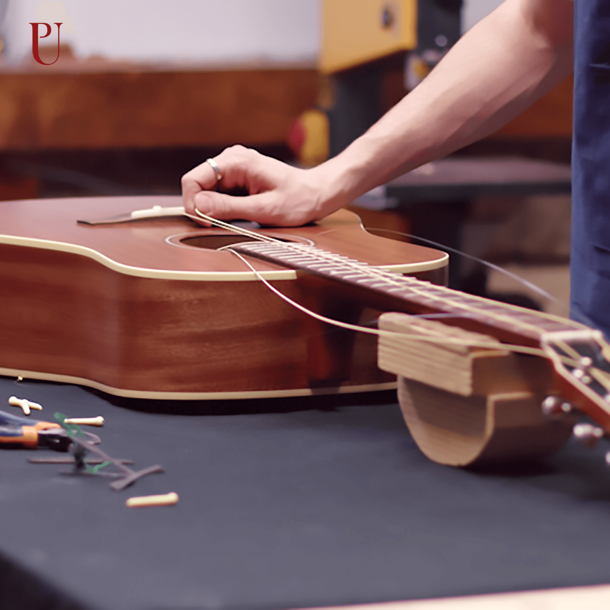 A hand working on a guitar
